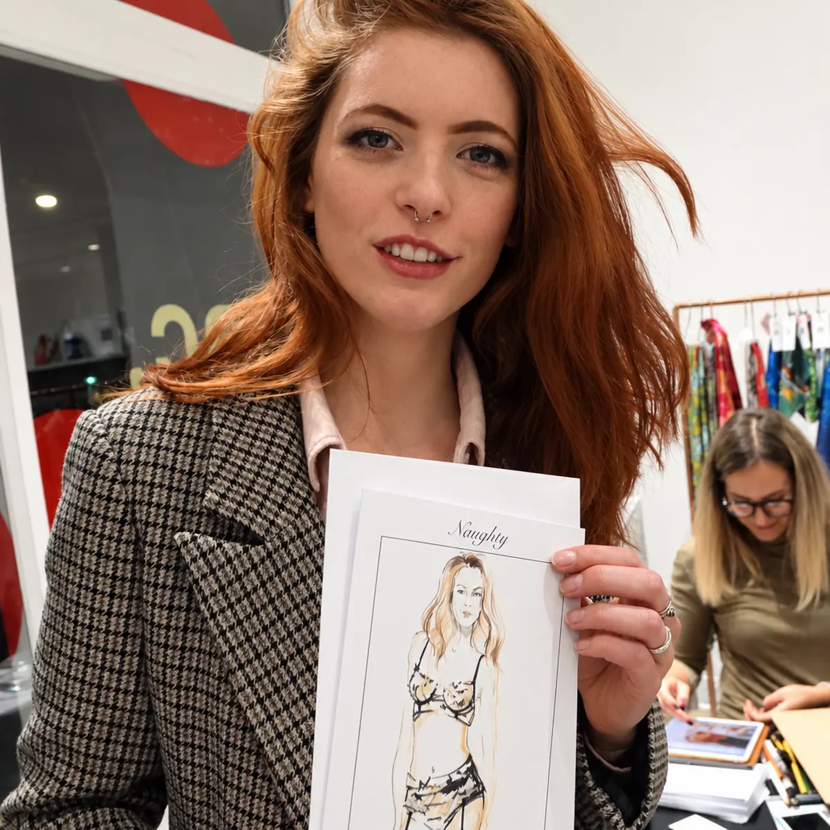 Guest at a store event holding her fashion sketch